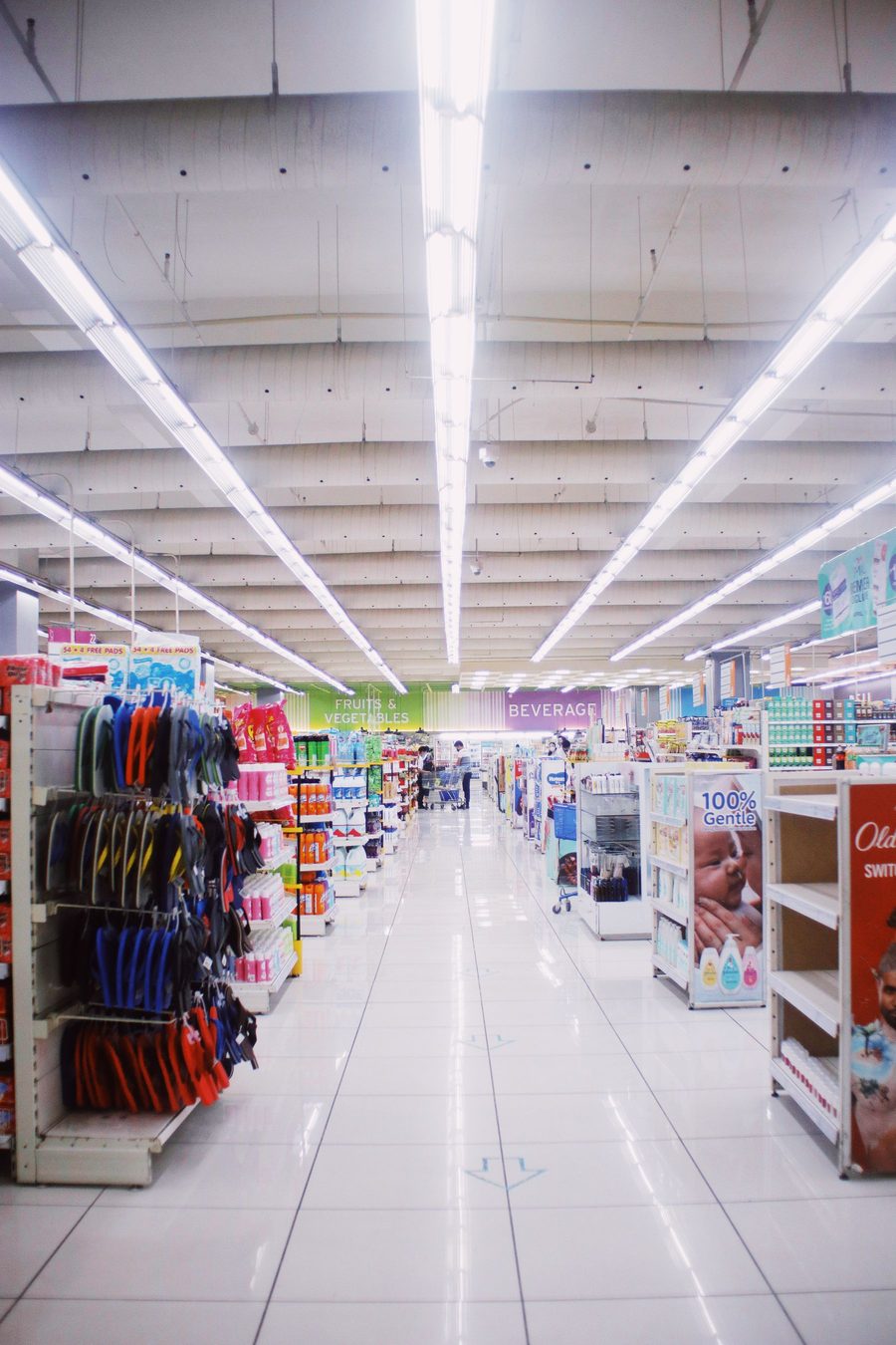 A well-lit modern pharmacy aisle stocked with health products