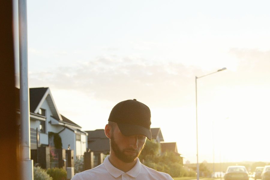 A courier carrying a delivery package along a residential street
